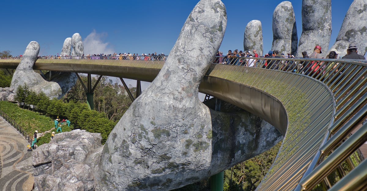 The iconic Golden Bridge with giant hand sculptures at Ba Na Hills, Vietnam, under a clear blue sky.