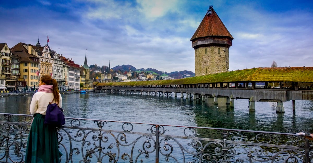 Traveler admires Chapel Bridge and Water Tower in Lucerne, Switzerland.